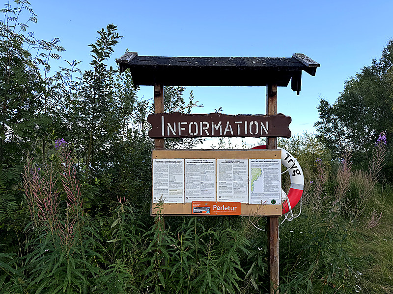 A wooden information board at the Pasvik riverside